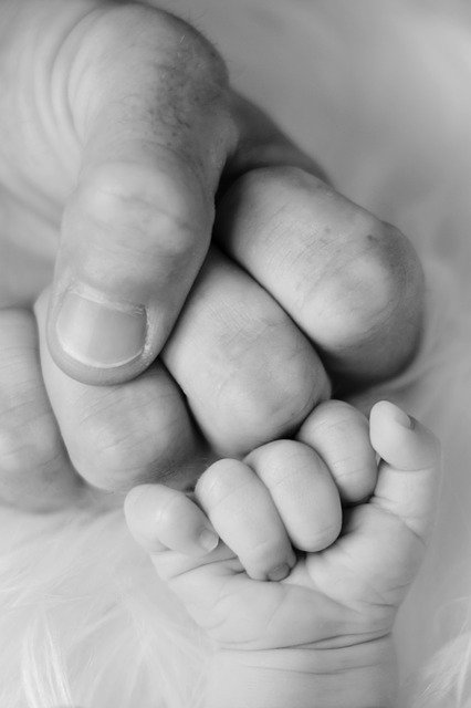 mani adulto con mani neonato